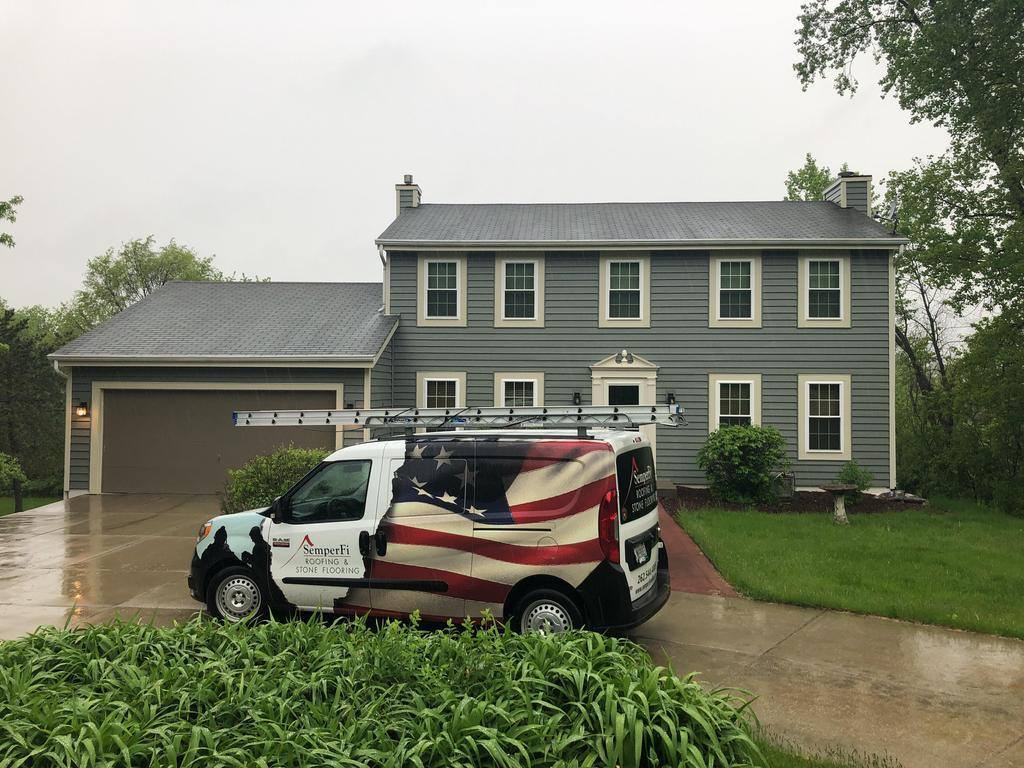 A Semper Fi Roofing & Exteriors van in front a Wisconsin home. 