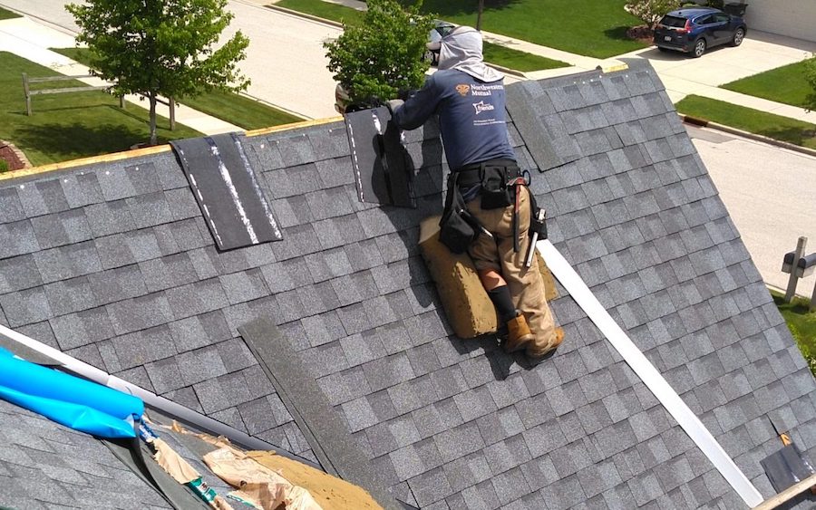 Semper Fi Roofing worker in the middle of a roof repair on a Milwaukee, WI, house