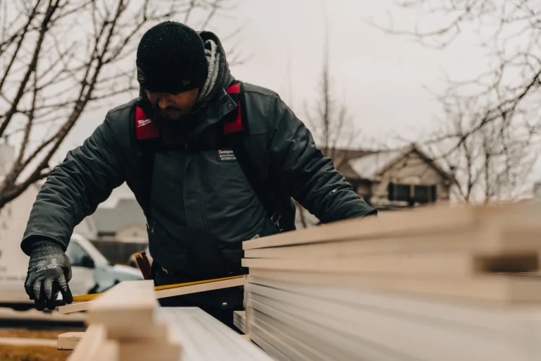 man measuring 2x4s on a roof
