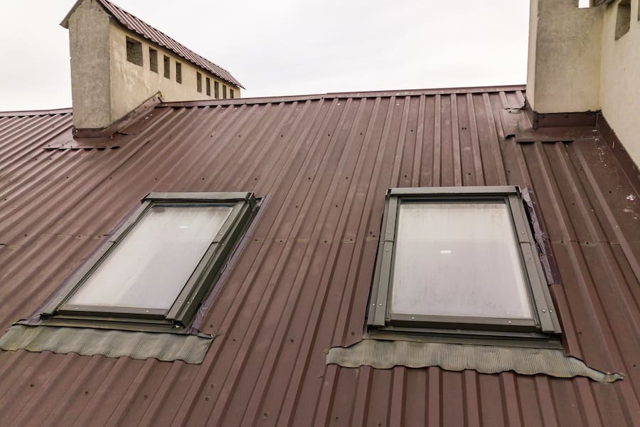 Roof of a house made from metal sheets with attic windows
