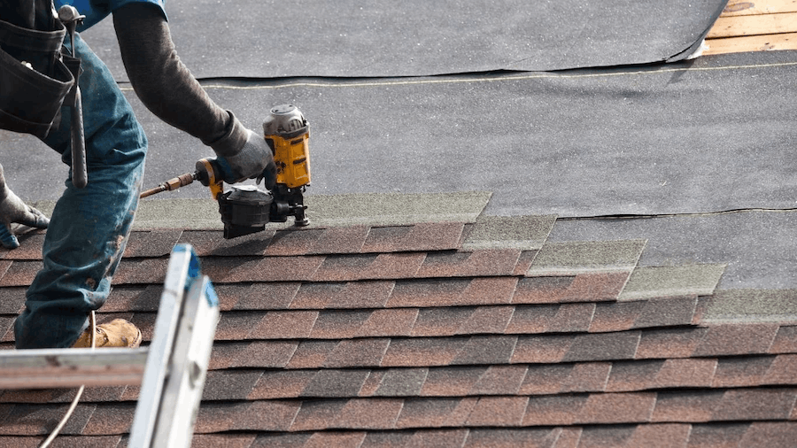 Roofer installing shingles